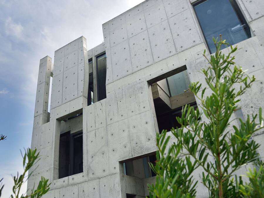 A modern building with a concrete facade and multiple windows.
