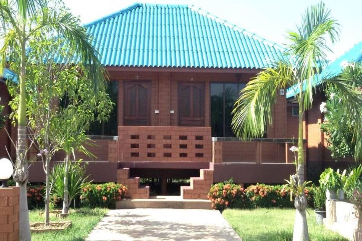 A building with a blue roof, brick walls, and a central entrance with steps.