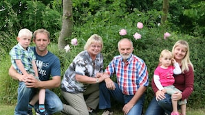 A family of five in a garden setting with greenery and flowers in the background. - Vacation apartment Stör - Ferienhof Röhling between Schlei and Baltic Sea (Kappeln)