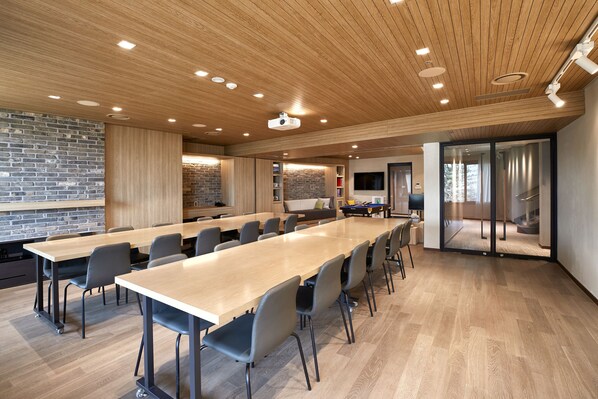 A conference room with a long table, chairs, and a projector.