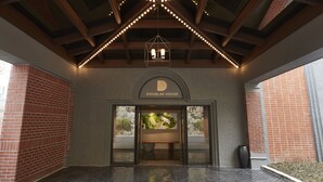 The entrance of Douglas House with a brick facade, a wooden ceiling with string lights, and a sign above the entrance. - Walkerhill Douglas House (Seoul)