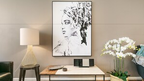 A modern living room with a wooden coffee table, a floor lamp, a framed artwork, and a potted orchid plant. - BOUTIQUE STAYS - Sandy Breeze 3 (Sandringham)