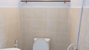 A small, clean bathroom with a toilet, sink, and shower. - Kedsila Hometel (Pathio)