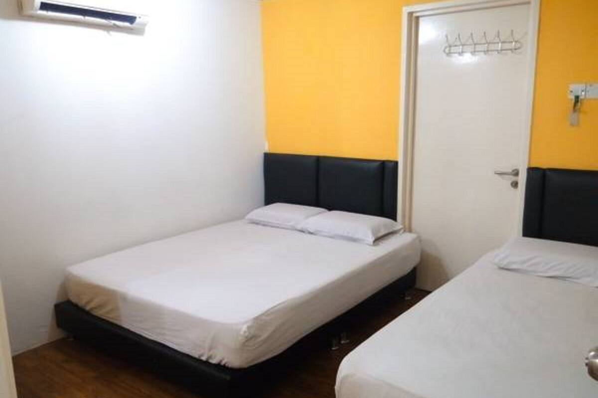 Een kleine hotelkamer met een bed, een kledingkast en een deur.