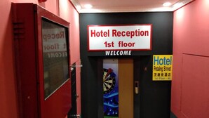 A hotel reception area with a sign indicating 'Hotel Reception 1st floor' and a welcome sign.