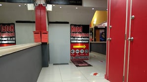 A hotel reception area with a 'Welcome Petaling Street Hotel' sign, a directory for rooms 55 & 57, and a contact number.