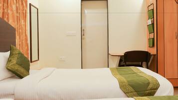 A hotel room with a bed, a desk, a chair, and a wardrobe.