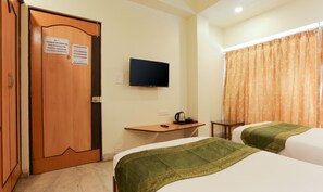 A hotel room with two beds, a television, a desk with a kettle, and a door with a sign. - Itsy Hotels Hill View Ex (Pune)
