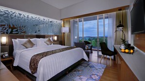 Une chambre d’hôtel moderne, dotée d’un grand lit, d’un bureau et offrant une vue sur l’extérieur.
