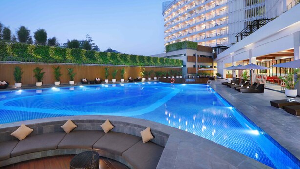 Un hôtel doté d’une piscine, d’un espace extérieur aménagé et d’un bâtiment comportant plusieurs balcons.