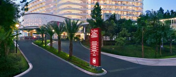 Entrada de un hotel con un cartel que anuncia servicios como salas de reuniones, un restaurante y un bar en la azotea.