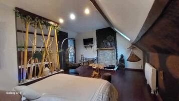 Une chambre moderne avec un grand lit, une petite table et un mur décoratif agrémenté de plantes.