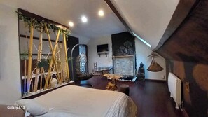 A modern bedroom with a large bed, a small table, and a decorative wall with plants. - Secret d'une nuit (Vicq)