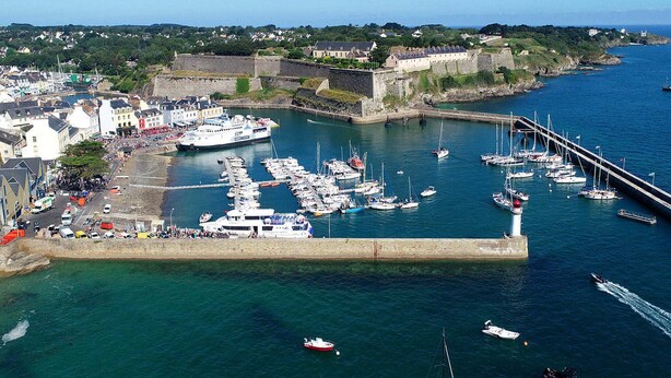 A harbor with boats docked, a lighthouse, and a fortified structure in the background. - Independent house with beautiful garden near Le Palais (Le Palais)