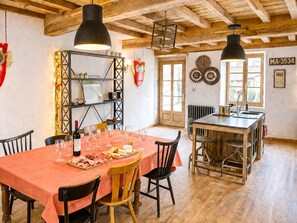 A dining area with a wooden table set for a meal, a bar area, and a view of the outside.