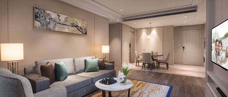 A modern living room with a grey sofa, a round coffee table, and a TV.