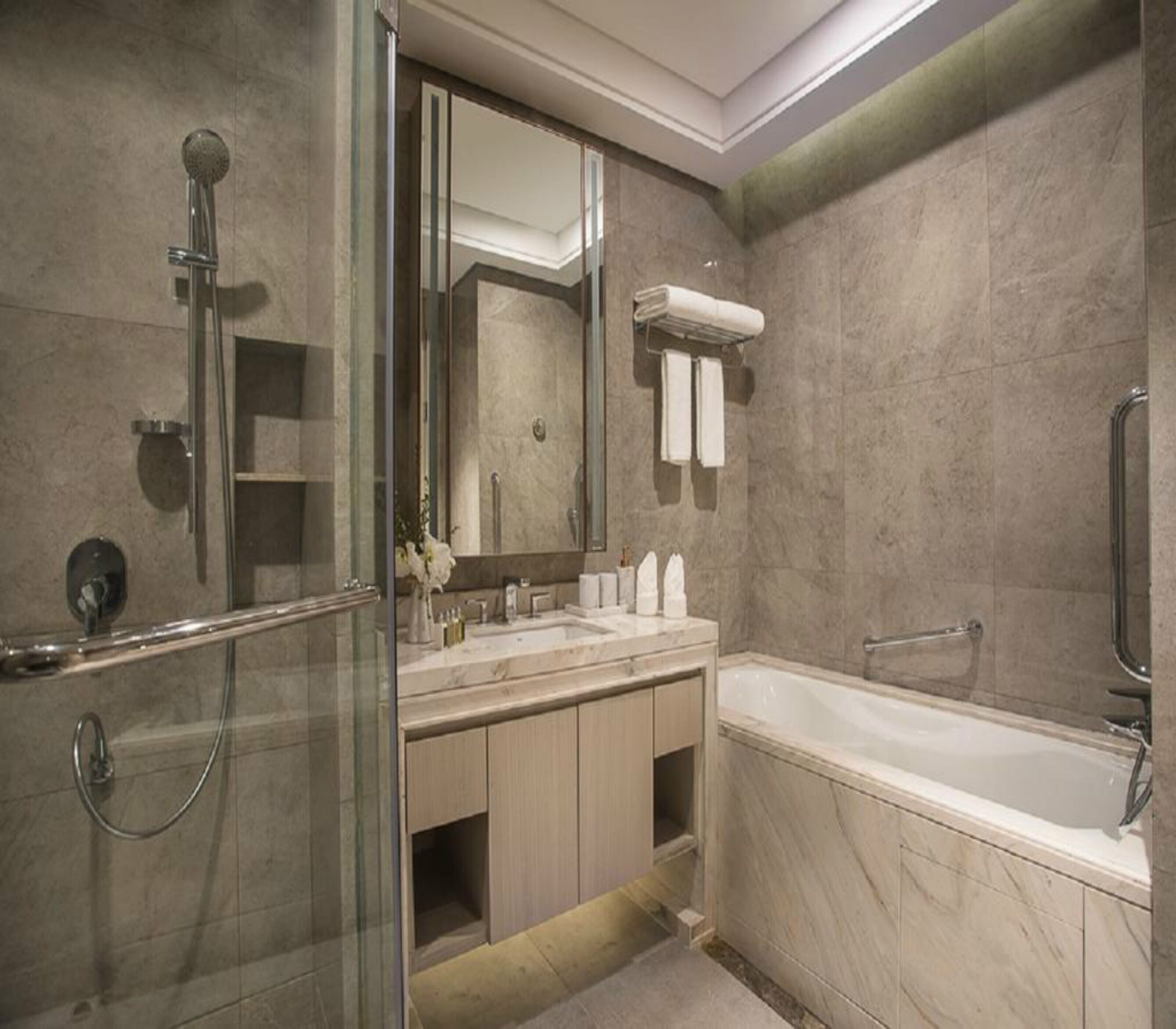 A modern bathroom with a glass-enclosed shower, a freestanding bathtub, and a vanity with a mirror.