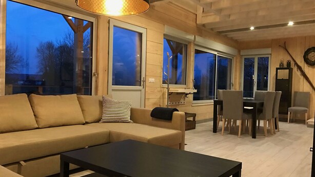 Un salon moderne avec un canapé, une table basse et un coin repas.