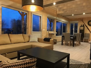 A modern living room with a sofa, coffee table, and dining area.