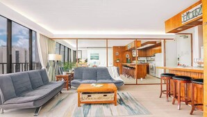 Een moderne woonkamer met een bank, salontafel en barstoelen.