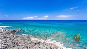 A clear view of a rocky shoreline with turquoise waters and a clear sky. - Direct oceanfront condo with A/C @ Sea Village (Kailua-Kona)
