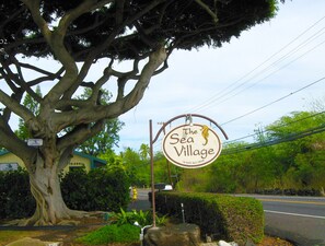 Uma grande árvore com uma placa indicando o restaurante