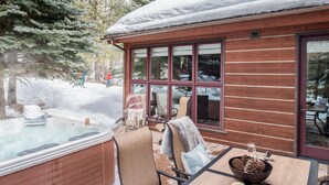 A wooden cabin with a hot tub, a table with chairs, and a snowy outdoor area. - Outpost: Moose Creek 20 - Private Hot Tub! (Teton Village)