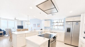 A modern kitchen with a central island, stainless steel appliances, and a dining area with a view. - Corner Unit A1110 Kng/Qn/Bunk/Sofa Sleeper Direct Gulf View-WIFI - Sleeps 9 (Gulf Shores)
