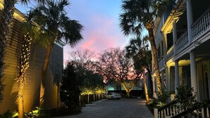 A paved courtyard with palm trees and a building with columns and a balcony. - AWESOME PROPERTY, GREAT DOWNTOWN CHARLESTON LOCATION! Sleeps 10 (Charleston)