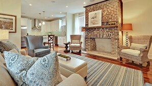 A living room with a fireplace, sofas, and a dining area. - AWESOME PROPERTY, GREAT DOWNTOWN CHARLESTON LOCATION! Sleeps 10 (Charleston)