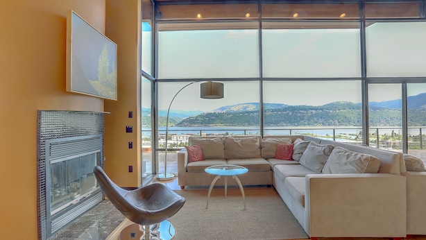 A modern living room with a large window, a sofa, a chair, and a fireplace. - Alizes - Luxury, Flagship Best Gorge Views, Downtown, Theater Room, Exceptional (Hood River)