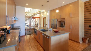 Una cocina moderna con armarios de madera, electrodomésticos de acero inoxidable y una isla central.