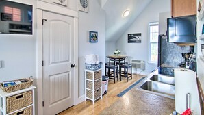 A kitchen with a refrigerator, sink, and wooden cabinets. There is a dining area with a table and chairs. - Coldsmoke Getaway, Steps From Meyers Lake & minutes from downtown! (Bozeman)