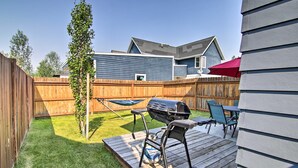 A backyard with a wooden deck, a grill, and a hammock. - Coldsmoke Getaway, Steps From Meyers Lake & minutes from downtown! (Bozeman)
