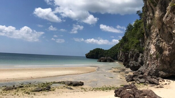 A beach with clear skies, a sandy shore, and rocky cliffs. - Room 9 Hometel (Pathio)