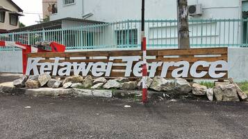 A sign for "Ketawei Terrace" with a wooden fence and rocks in front.