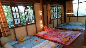 Habitación con tres camas, cada una con una colcha con motivos de Winnie the Pooh.