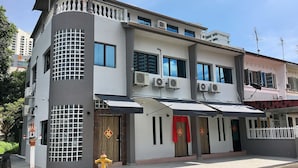 A modern building with multiple windows, air conditioning units, and a fire hydrant in front. - iBook8 Superior 1 Bedroom Gurney Suites  by iBook Homestay (George Town)