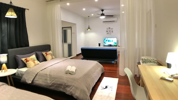A modern hotel room with a bed, a desk, a TV, and a ceiling fan. - iBook8 Superior 1 Bedroom Gurney Suites  by iBook Homestay (George Town)