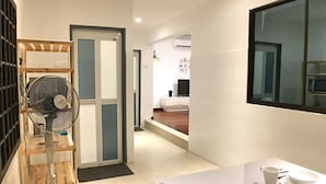 A modern kitchen with a dining area, a built-in fan, and a view into the living room. - iBook8 Superior 1 Bedroom Gurney Suites  by iBook Homestay (George Town)