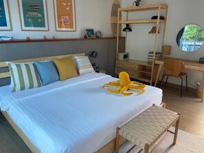 A bedroom with a bed, a desk, a chair, and a round mirror. - MJ Boutique Hotel Khao Lak (Thai Mueang)