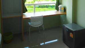 A room with a window, a chair, a small table, and a refrigerator. - Sleepwell@Naiyang (Sa Khu)