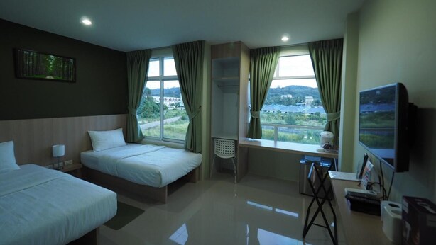 A hotel room with two beds, a desk with a chair, a TV, and a window with curtains. - Sleepwell@Naiyang (Sa Khu)