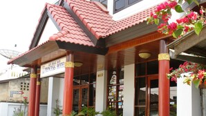 The exterior of Ain Shae San Princess Hotel with a traditional architectural style, featuring a tiled roof and a signboard. - Princess Hotel (Kengtung)