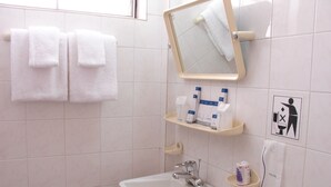 A bathroom with a sink, mirror, towel rack, and shelves with toiletries. - Princess Hotel (Kengtung)