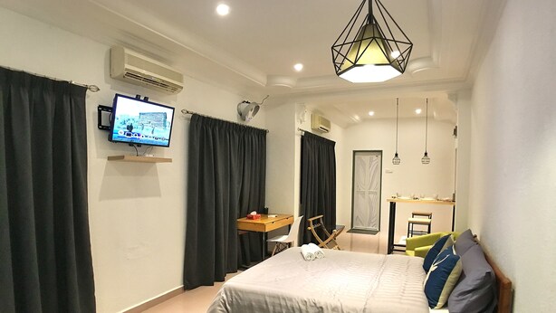 A hotel room with a bed, a desk, a chair, a TV, and a bathroom. - iBook9 Deluxe Family Suite by iBook Homestay (George Town)
