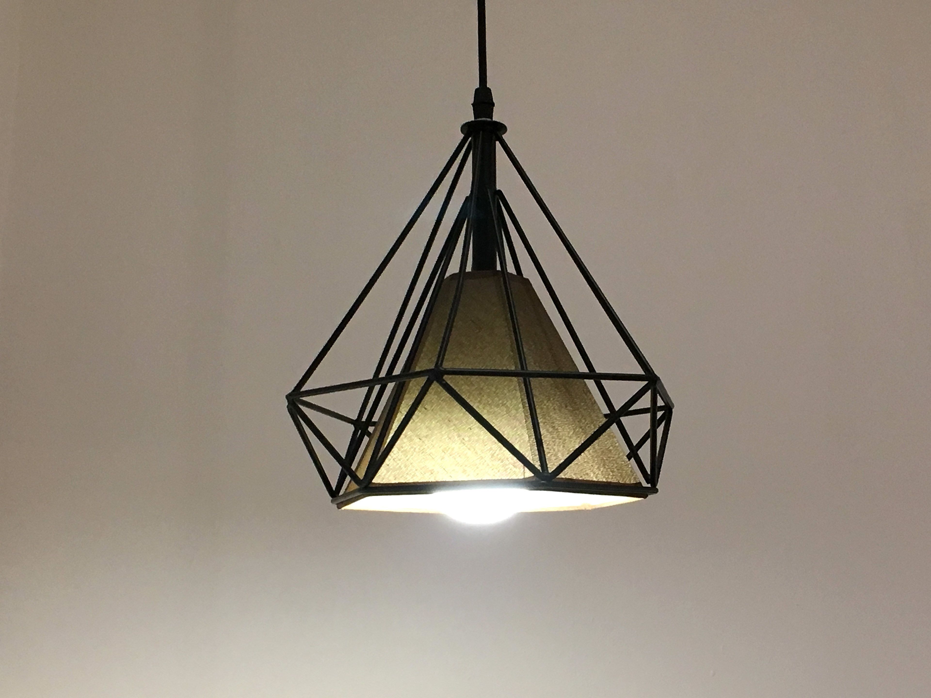 En geometrisk pendellampe med en lyskilde i midten.