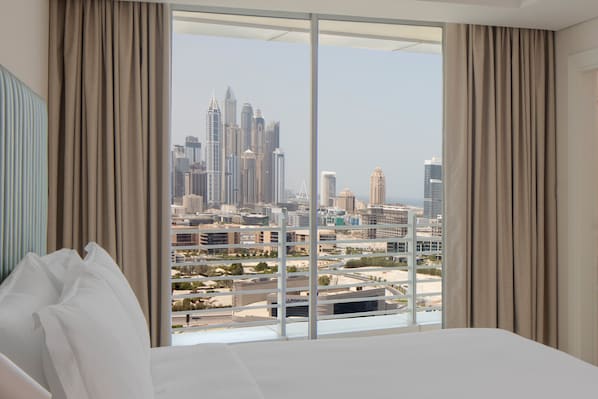Ein Hotelzimmer mit großem Fenster und Blick auf die Stadt.