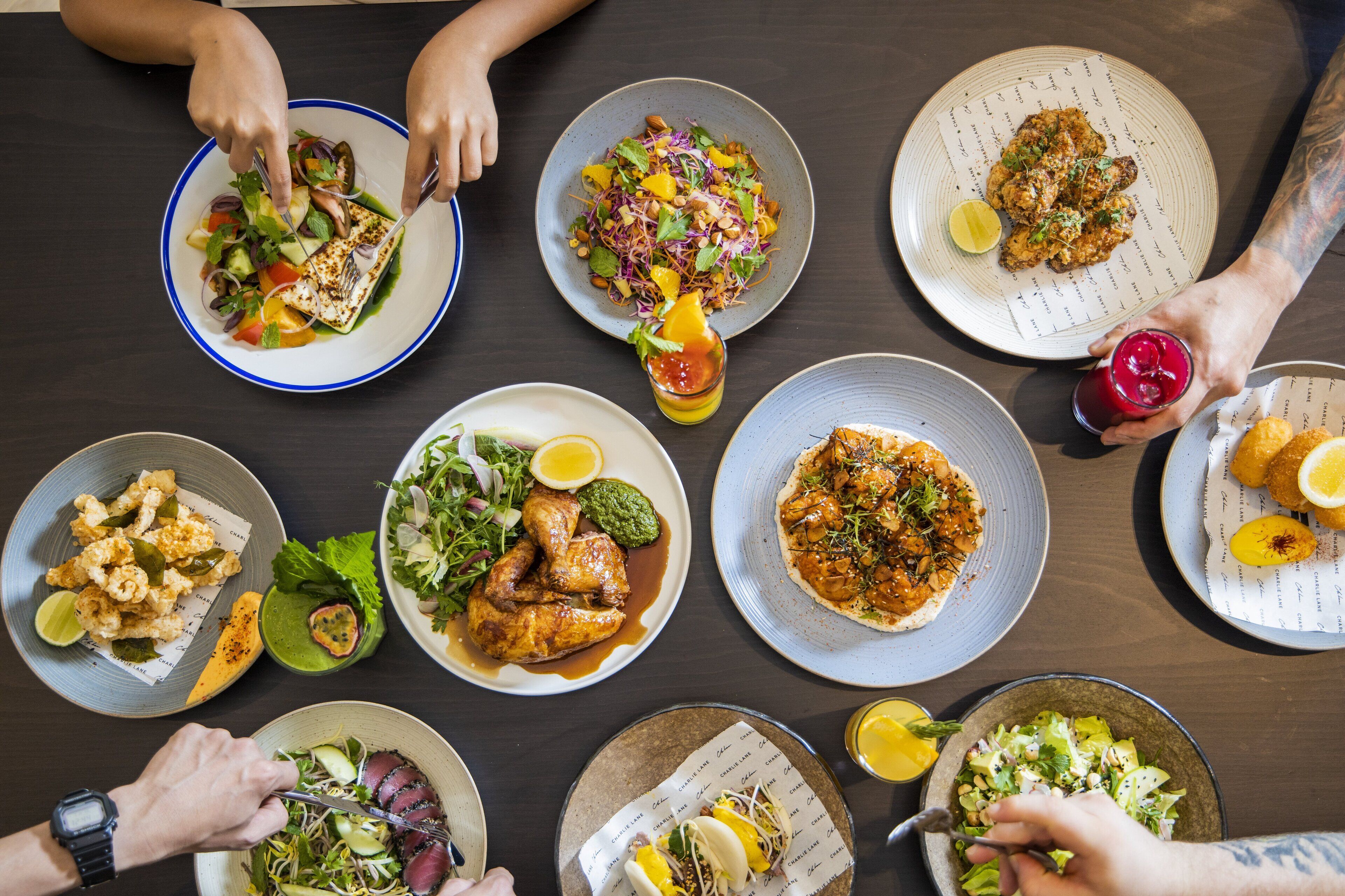 Une table à manger avec différents plats et des personnes qui mangent.