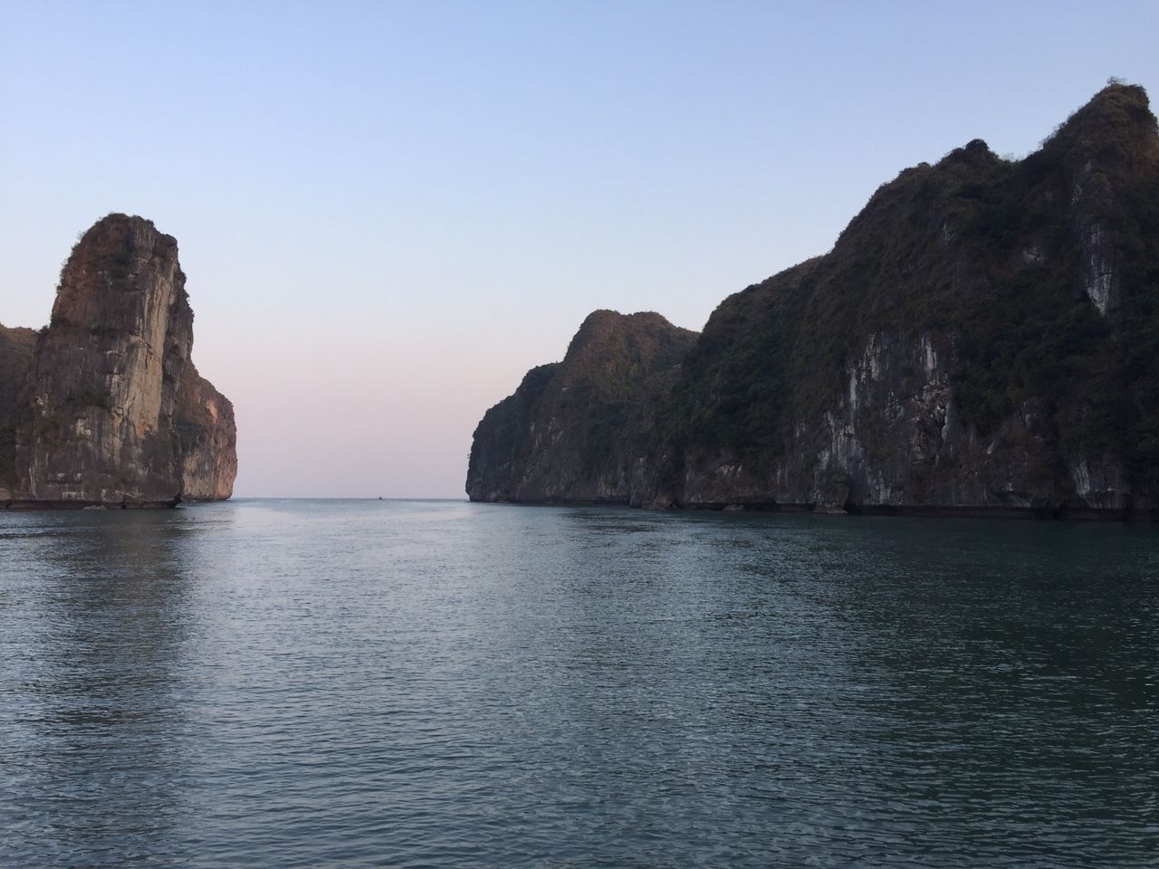 Un paisaje costero con grandes formaciones rocosas y agua tranquila.